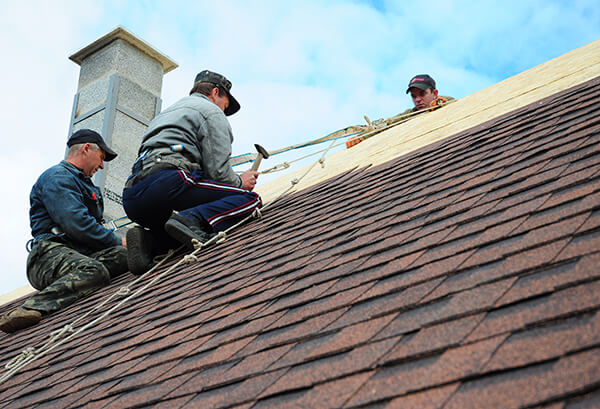 workers reroofing a house